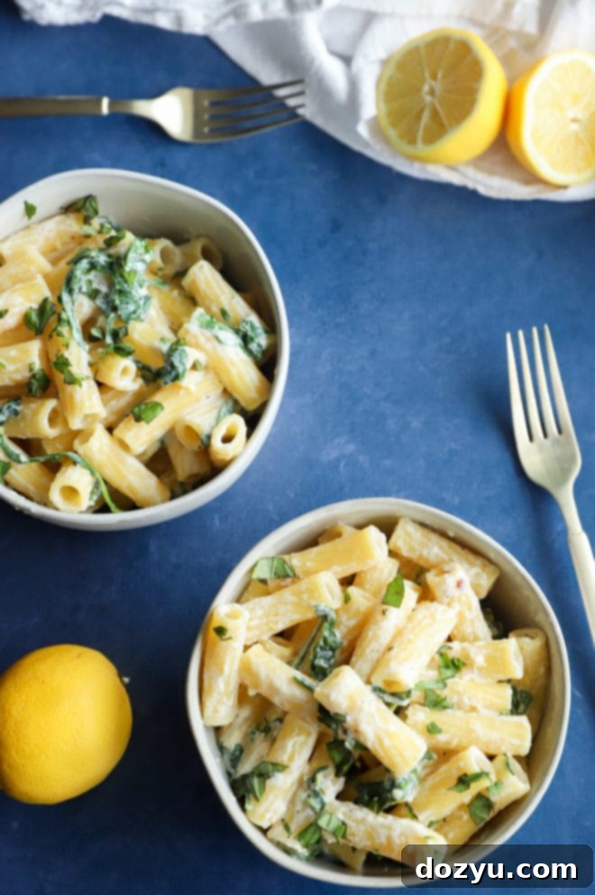 Lemony Cloud Pasta 5 Overhead image of lemon ricotta pasta in bowls, garnished with lemon wedges and fresh arugula