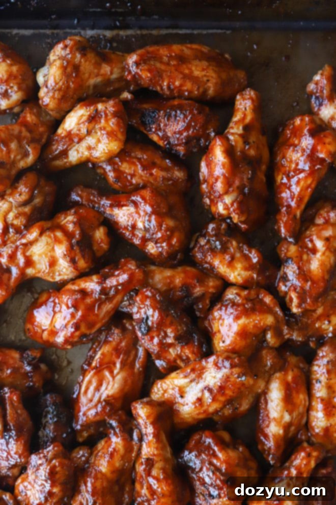 Glazed Honey BBQ Chicken Wings 2 Overhead image of chicken wings on baking sheet, glistening with honey BBQ sauce, ready to be served