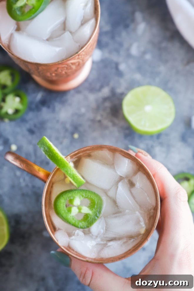Hand holding mug with jalapeno mexican mule