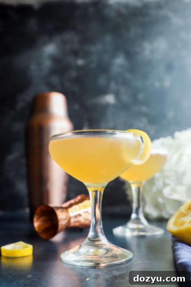 Side view of a single Bourbon Sidecar cocktail in a coupe glass, garnished with a lemon twist.