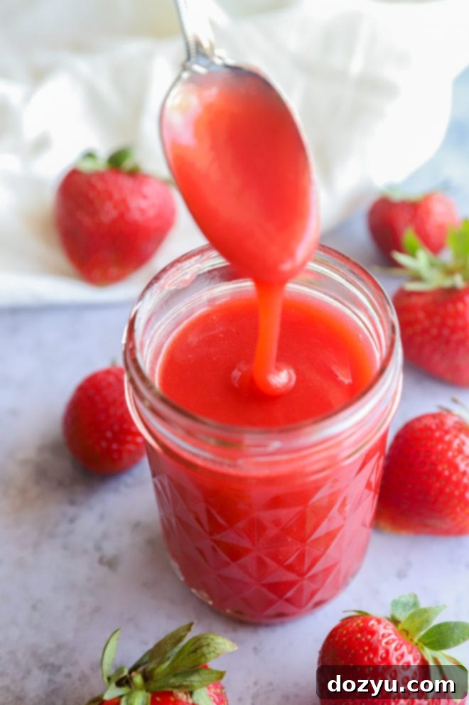 Spoon pouring in sauce for strawberries