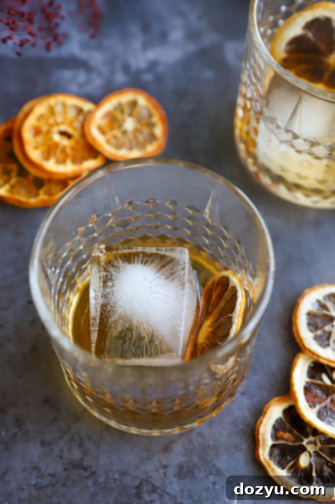 Smoldering Agave Classic 3 Photo of a cocktail hour setup with a Spicy Mezcal Old Fashioned, oranges, and a bottle of mezcal in the background.