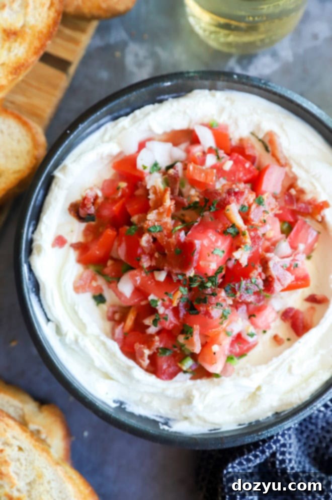 Creamy Whipped Goat Cheese Salsa Dip 2 Overhead image of a bowl of whipped goat cheese salsa dip, garnished with fresh herbs and surrounded by toasted bread slices.