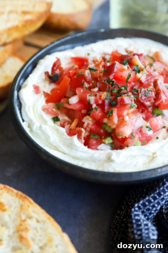 Creamy Whipped Goat Cheese Salsa Dip 3 Close-up image of whipped goat cheese salsa dip in a white bowl, showing the creamy texture and chunky salsa topping.