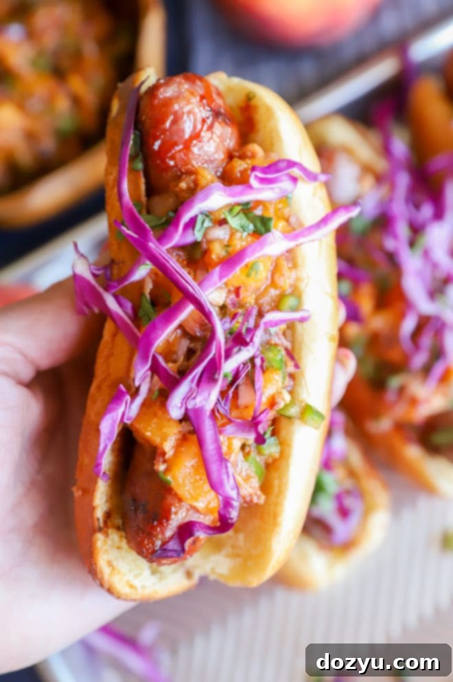 Sweet & Smoky Brats with a Peach-Bacon Kick 10 Hand holding bbq grilled bratwurst with peach salsa