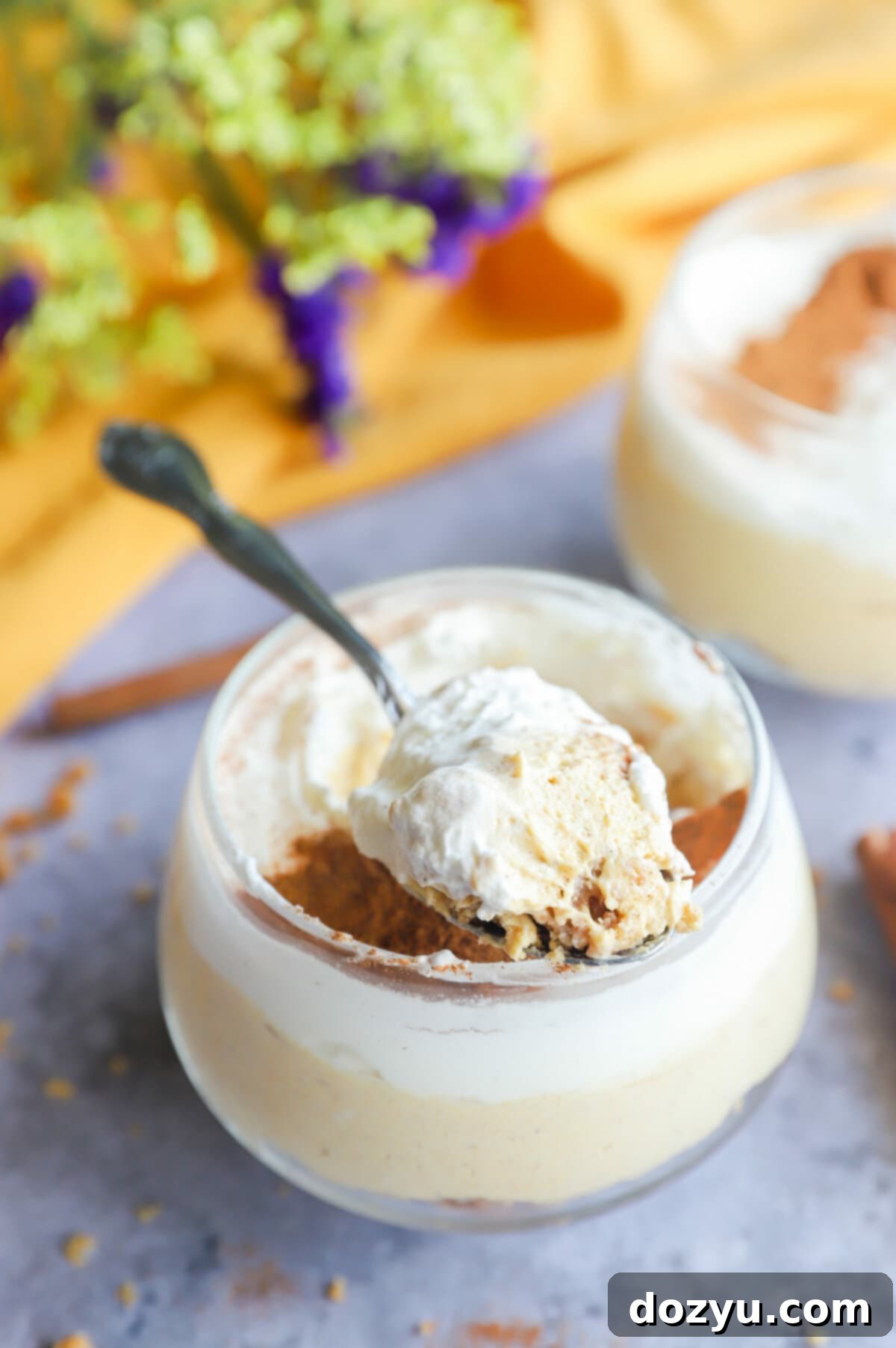 Spoonful of pumpkin cheesecake mousse picture with whipped cream and spices.