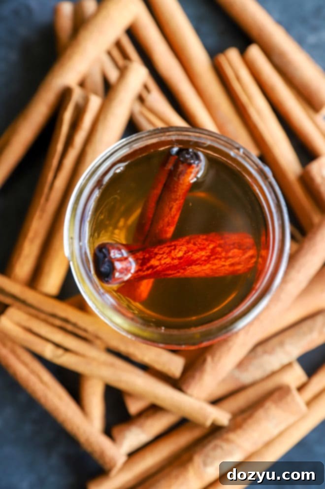 Freshly made Cinnamon Simple Syrup in a glass bottle with cinnamon sticks