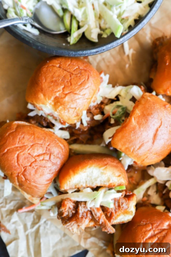 Tender BBQ Pulled Pork Sliders with Tangy Apple Coleslaw 2 Overhead image of pulled pork sliders and apple coleslaw, showcasing their delicious presentation on a wooden board