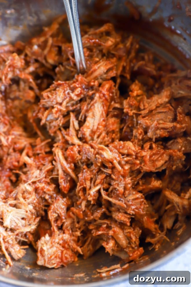 Tender BBQ Pulled Pork Sliders with Tangy Apple Coleslaw 6 BBQ pulled pork in a large bowl, glistening with sauce