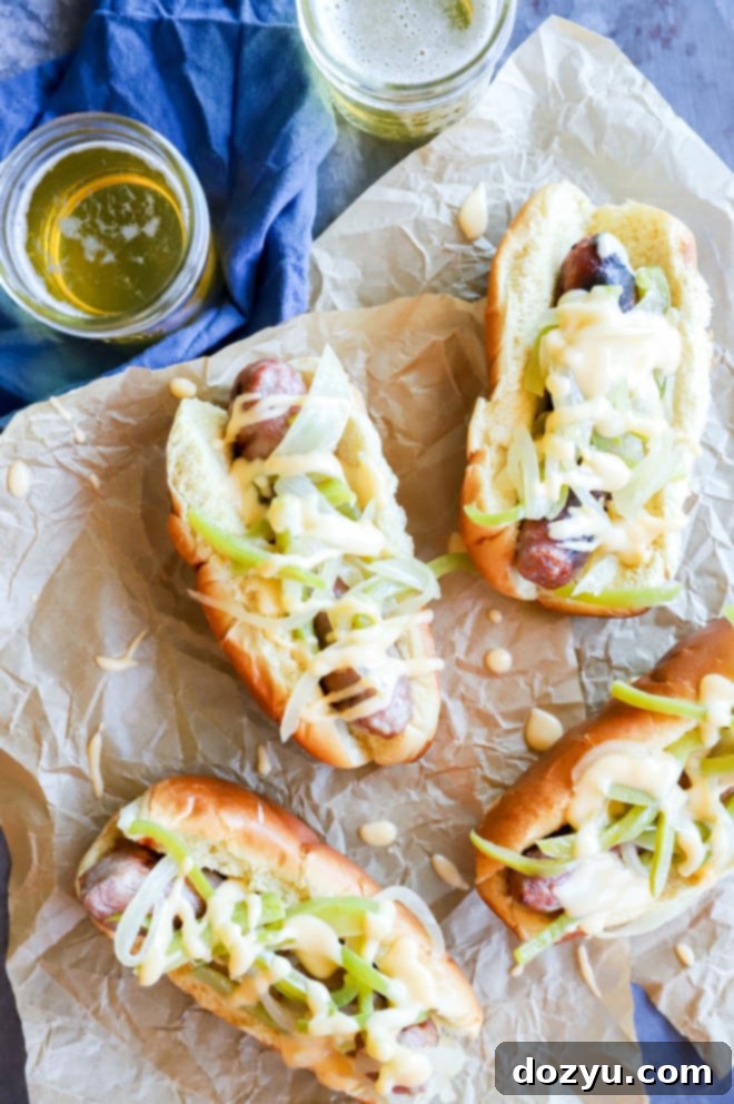 Philly Cheesesteak Beer Brats 10 Overhead view of a delicious Philly cheesesteak bratwurst in a bun, loaded with toppings.