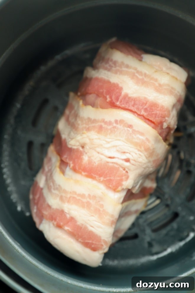 Crispy Air Fryer Bacon Wrapped Pork Loin 6 pork loin in air fryer before cooking picture