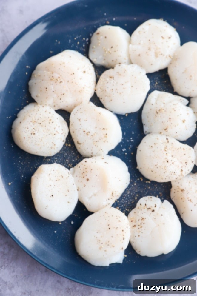 Effortless Air Fryer Scallops with Bright Chive Lemon Butter 5 Raw scallops on a plate seasoned with salt and pepper