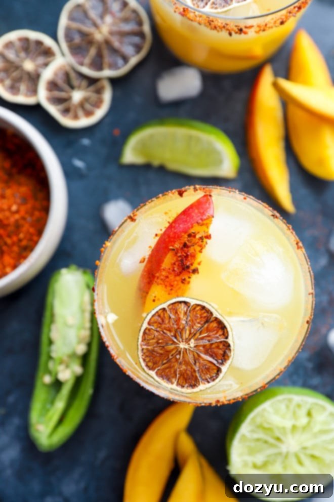 Spicy Mango Margarita Vibrant and colorful Spicy Mango Margarita cocktail in a glass, garnished with fresh lime and a mango slice.