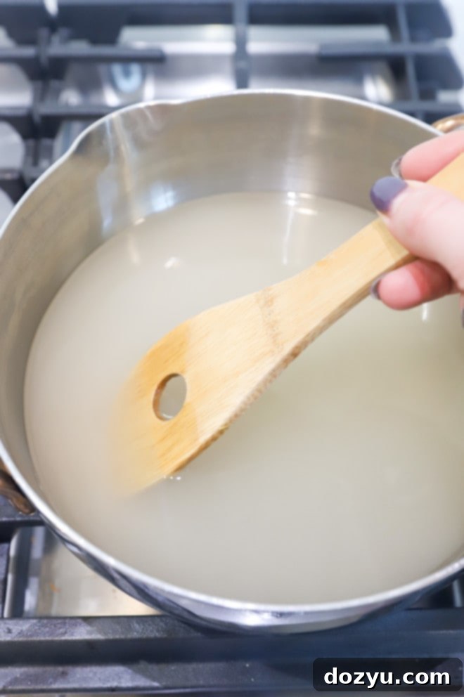 Easy Homemade Simple Syrup 4 Stirring sugar mixture in a saucepan photo