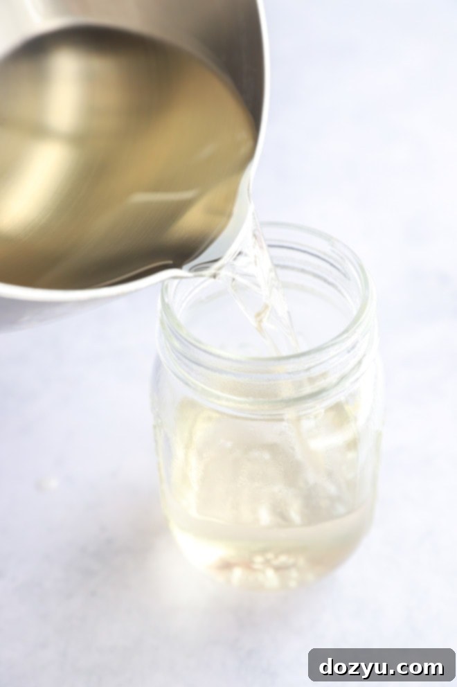 Easy Homemade Simple Syrup 6 Pouring syrup into a jar from a saucepan image