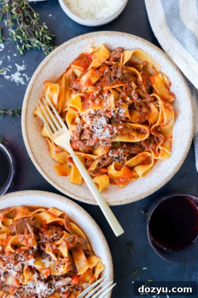 Fall-Off-The-Bone Instant Pot Short Rib Ragu 2 Overhead image of Instant Pot short rib ragu served with wide pasta and fresh parsley garnish.