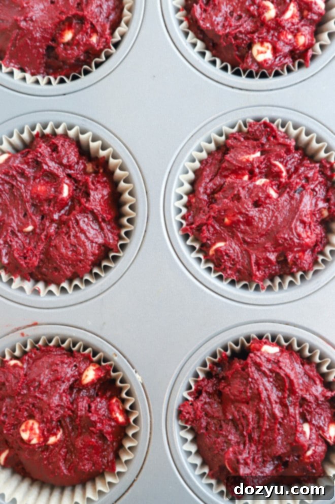 Crimson Velvet Indulgence 6 Red velvet muffin batter expertly divided into a muffin tin with liners.
