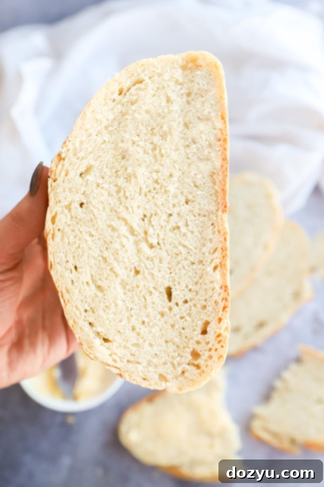 Effortless Overnight No Knead Bread 6 Hand holding a loaf sliced in half