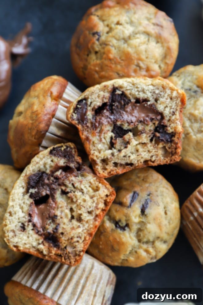 Decadent One-Bowl Banana Nutella Muffins 2 Banana muffins with chocolate chips and hazelnut spread in the center