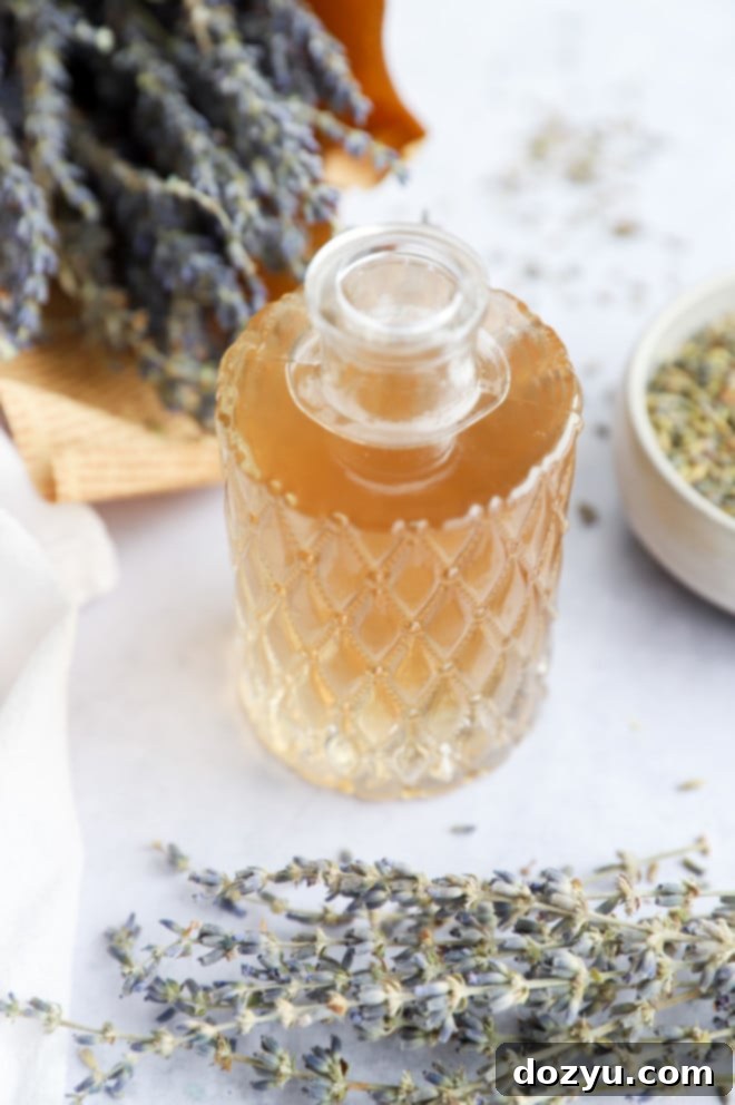 Fragrant Lavender Syrup 7 A mason jar filled with lavender simple syrup, sealed and ready for storage, with fresh lavender sprigs nearby.