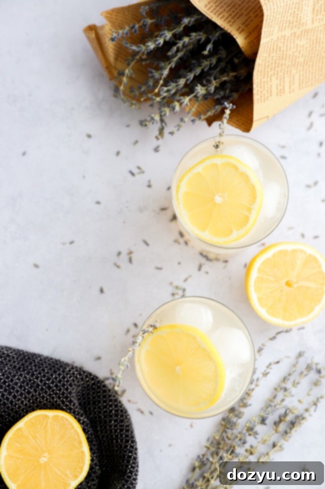 Blissful Lavender Lemonade Cocktail 3 Dried culinary lavender flowers and fresh lemons artfully arranged on a wooden surface, highlighting the key ingredients for a vodka drink.