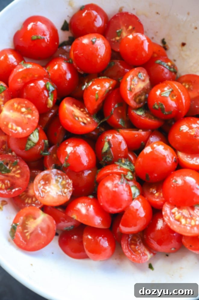 Creamy Burrata Caprese Salad 4 Image of tomatoes in a bowl with dressing