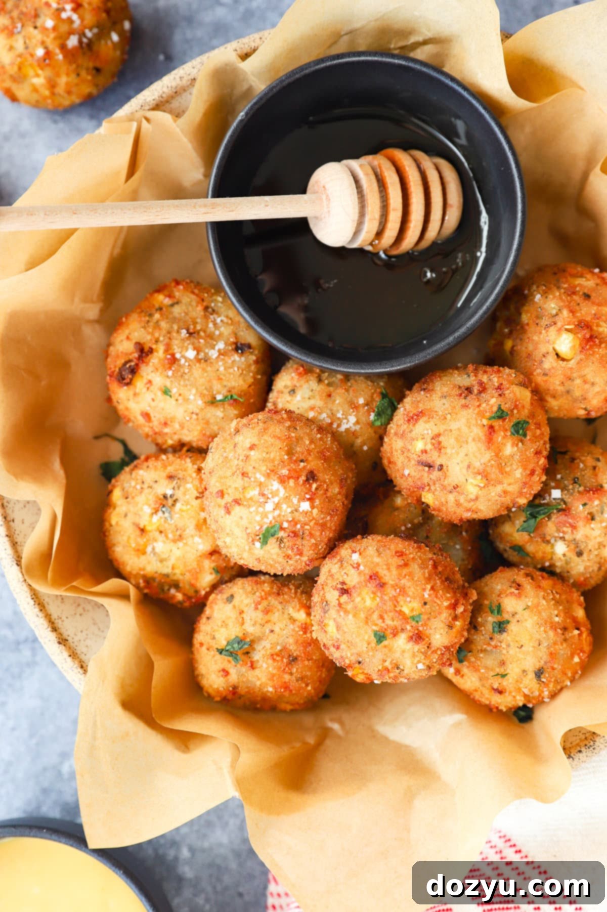 Cheesy Corn Bites 2 close up image of cheese corn balls in a bowl, showing their golden exterior and the soft interior
