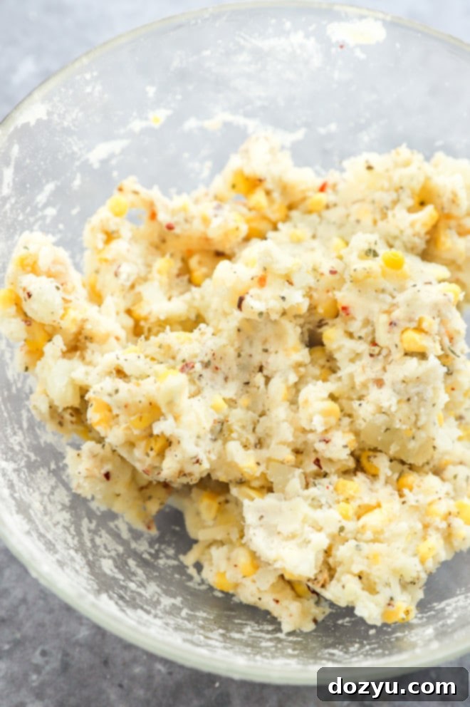 Cheesy Corn Bites 6 The combined mashed potato, corn, and cheese mixture in a bowl, showing its texture before forming into balls.