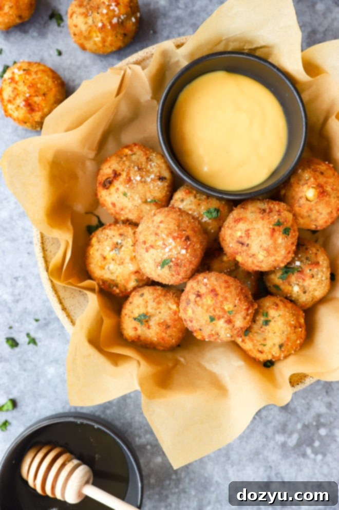 Cheesy Corn Bites 9 Overhead image of a bowl filled with various appetizers and snacks, including cheese corn balls.