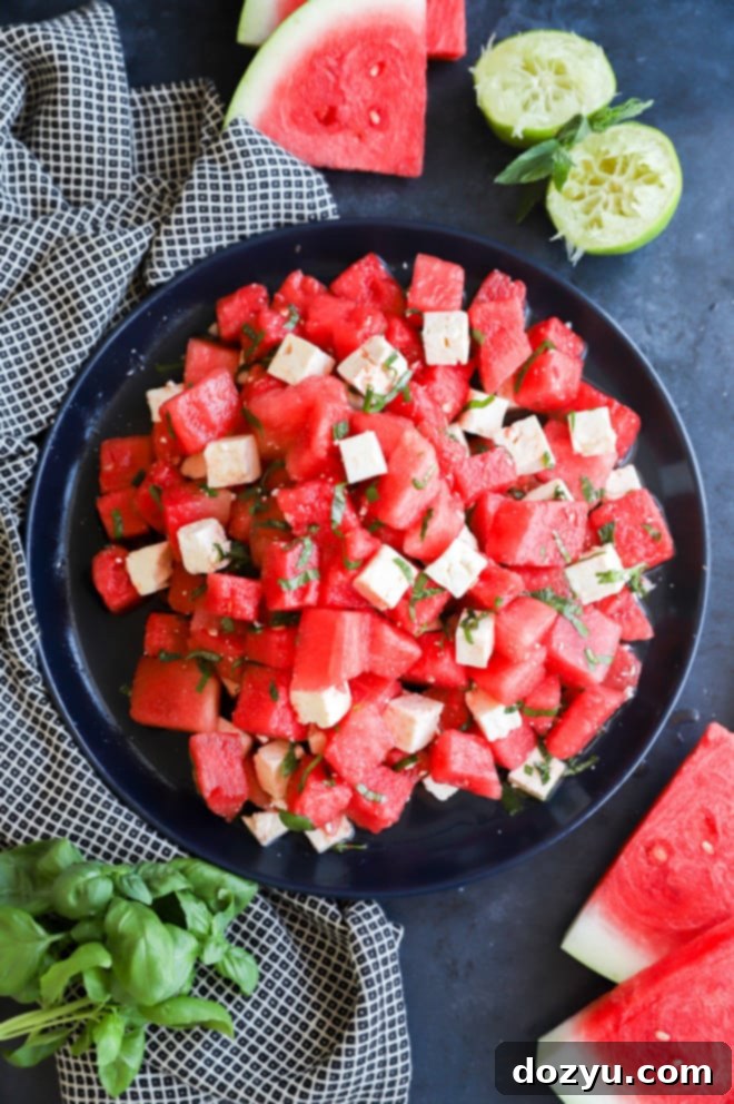 Refreshing Watermelon Feta Delight 2 A beautifully arranged serving platter of Watermelon Feta Salad, featuring vibrant red watermelon cubes, white crumbled feta cheese, and green basil leaves, perfect for a summer gathering.