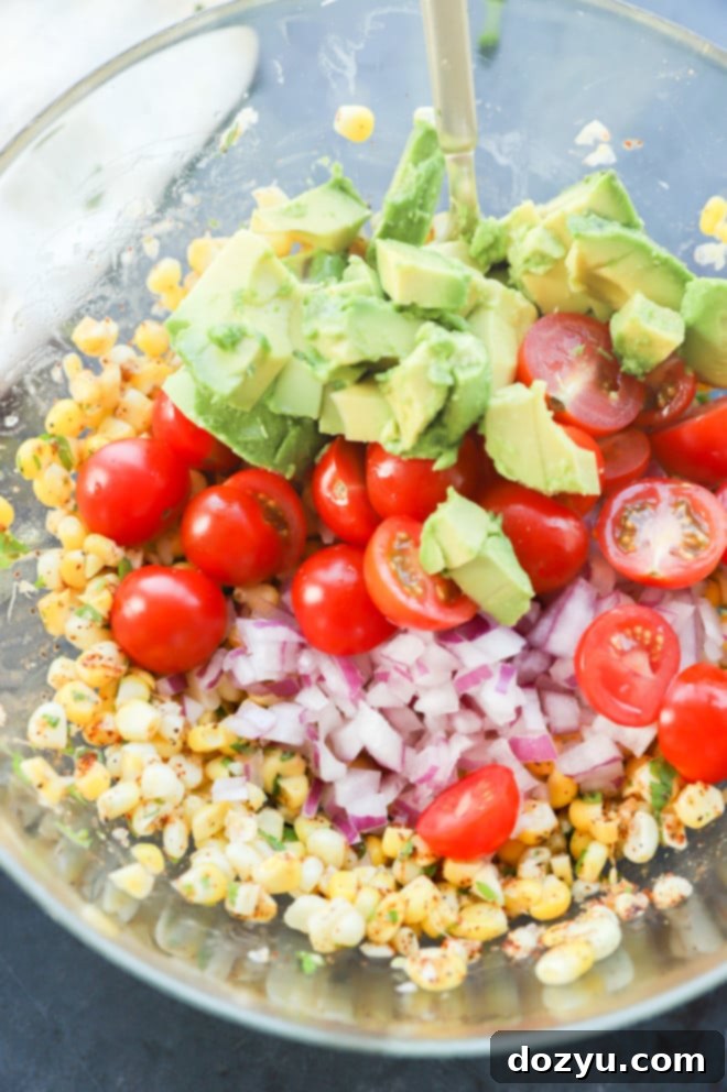 Vibrant Masala Corn Salad 5 Hands mixing fresh ingredients and spices into cooked corn kernels for the Masala Corn Salad.