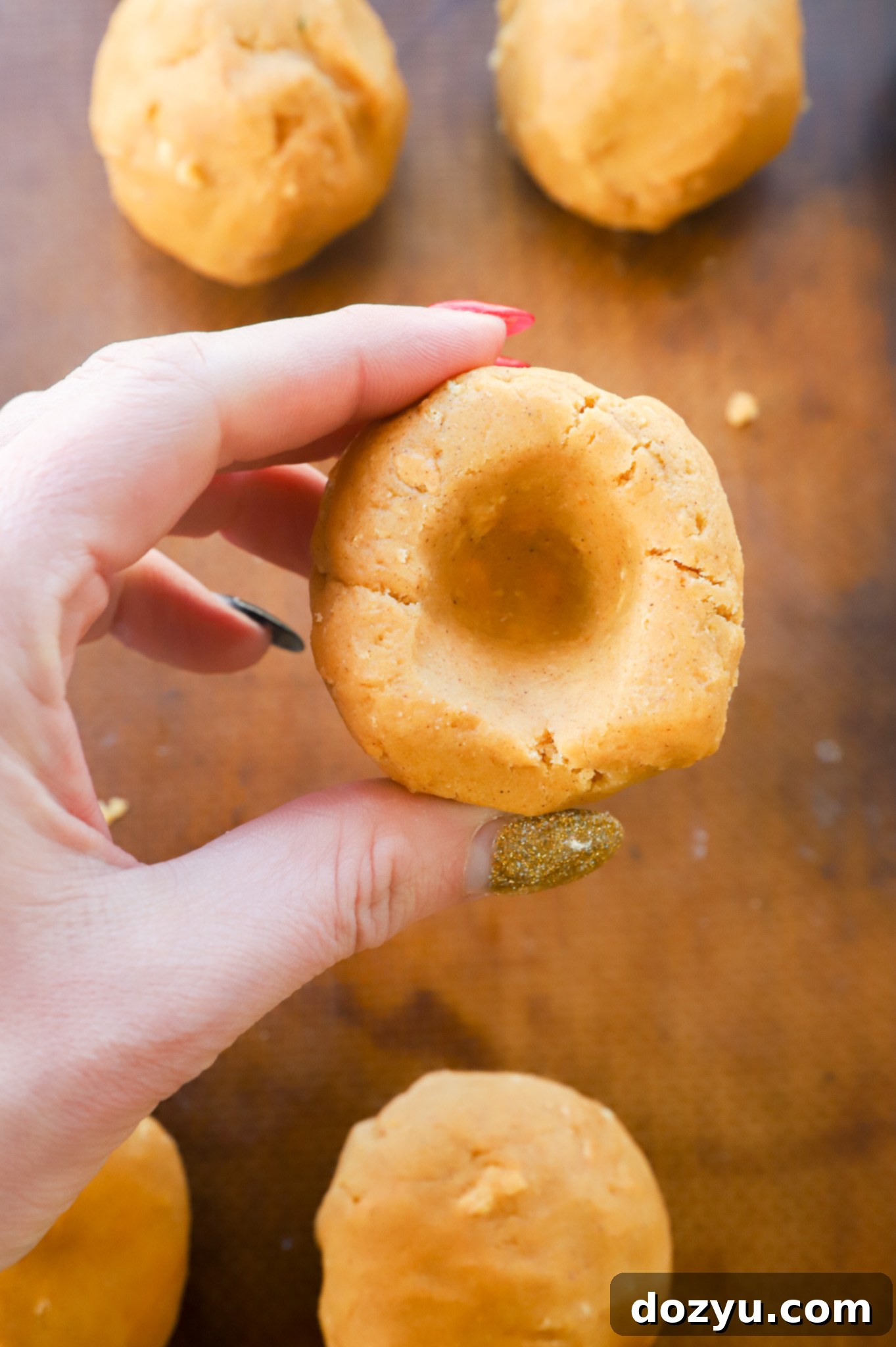 Spiced Pumpkin Cheesecake Cookies 5 showing how to make an indent in a ball of cookie dough