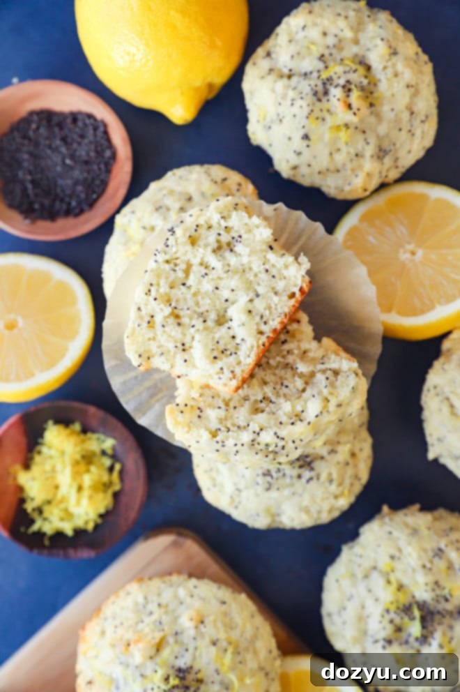 Sunshine Lemon Poppy Seed Muffins 2 Pile of fluffy lemon poppy seed muffins with paper liners, ready to eat