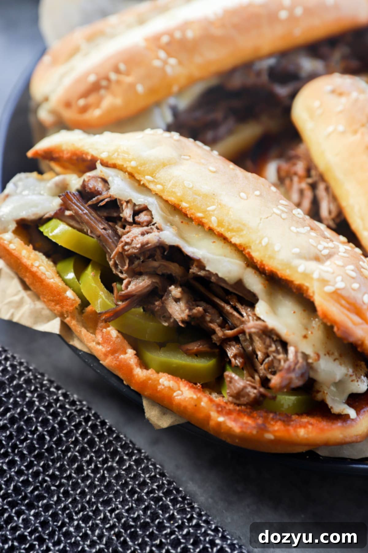 Ultimate French Dip 11 Image of a beef sandwich with hot peppers and cheese