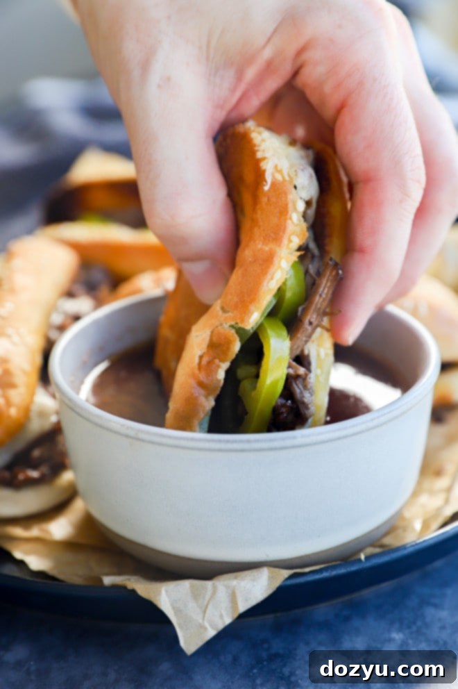Ultimate French Dip 10 Hand sinking a meal into au jus, showing the rich, savory broth