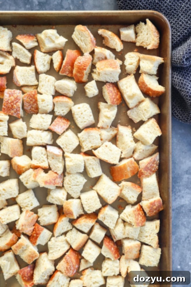 Perfect Sage and Onion Stuffing 5 Crispy, golden-brown toasted bread cubes spread evenly on a sheet pan, ready for making stuffing.