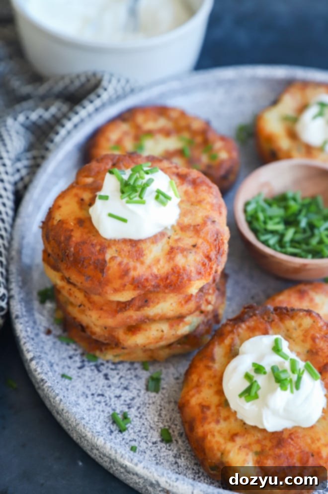 Crispy Potato Patties 2 Mashed potato fritters with sour cream and chives on a serving platter