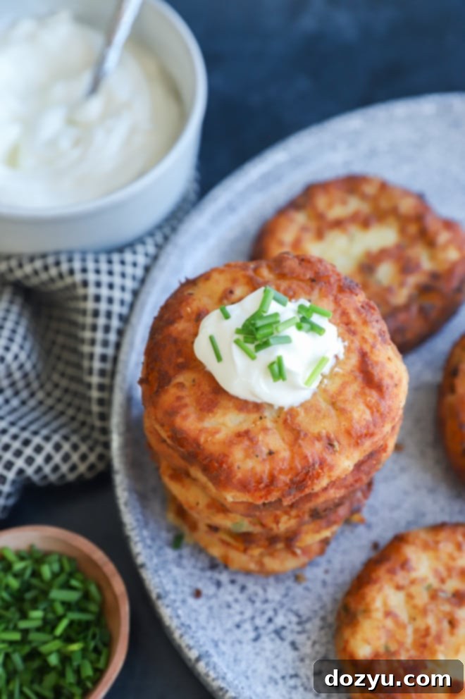 Crispy Potato Patties 9 fried pancakes in a pile on a platter with sour cream and chives