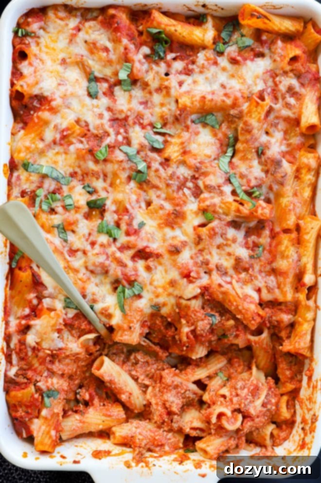 Classic Baked Rigatoni 8 Spooning out pasta al forno from a large baking pan