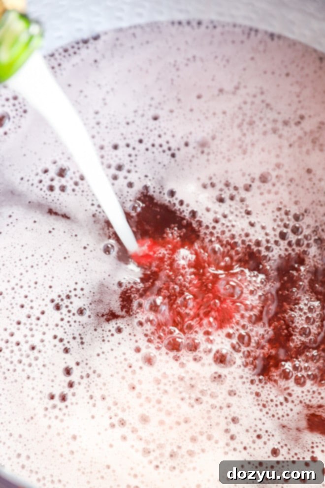 Your Guide to Festive Christmas Punches 5 pouring champagne into a punch bowl