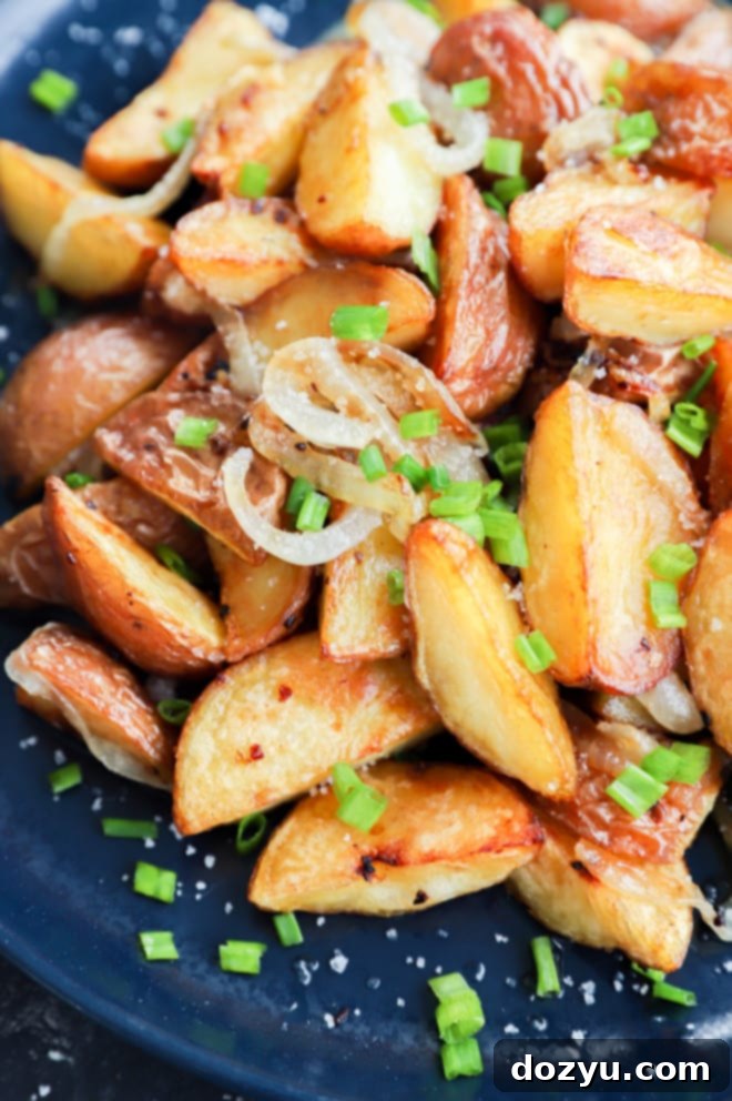 Crispy Oven Roasted Potatoes and Onions 6 Chives on top of fried potatoes and onions made in the oven
