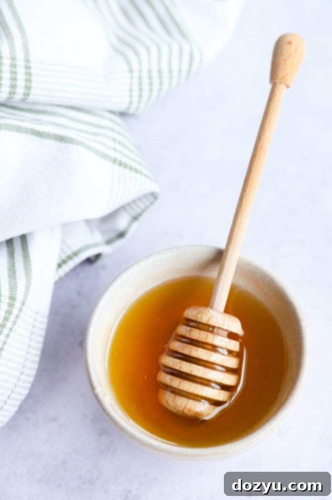 Honey Elixir 7 honey in a bowl with a honey stick