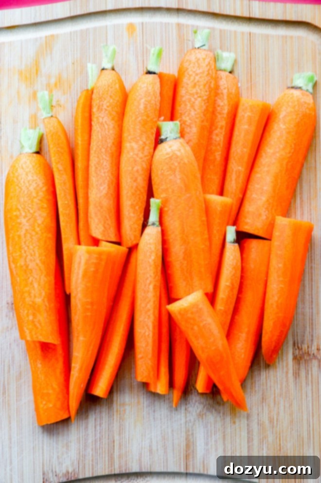Zesty Rapid Pickled Carrots 5 Carrots on a cutting board, some peeled and cut in half, ready for pickling.