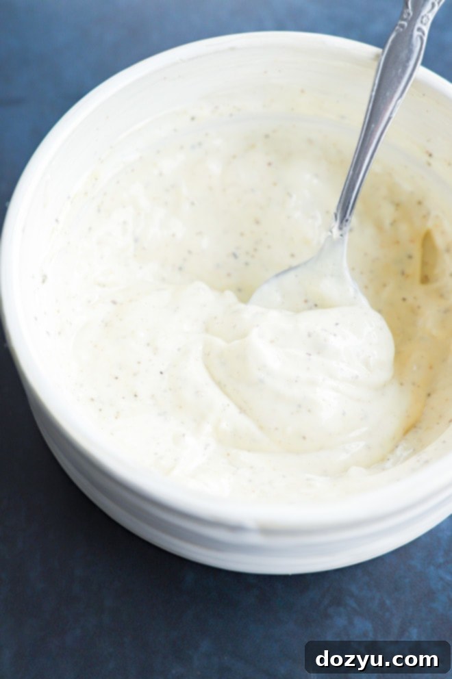 Homemade creamy garlic aioli in a bowl with a spoon, ready to be served