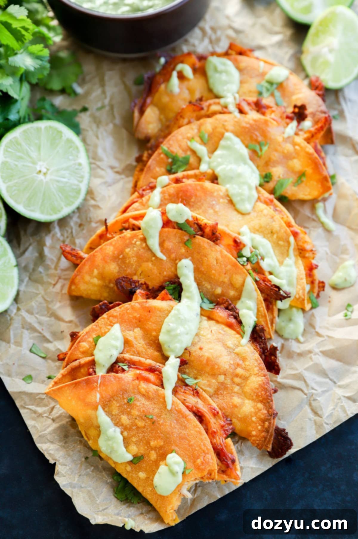 Zesty Crispy Chicken Tacos with Creamy Avocado Tomatillo 11 A close-up shot of a crispy baked chicken taco with a bite taken out, showing the flavorful filling and golden-brown shell.
