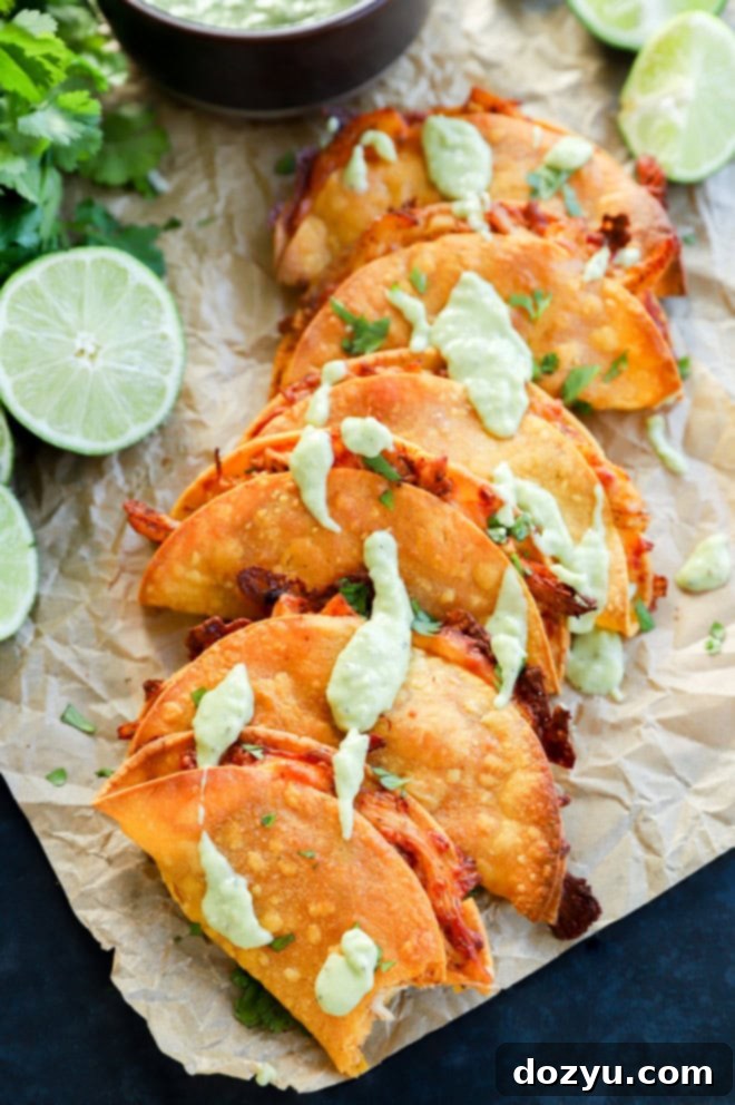 Zesty Crispy Chicken Tacos with Creamy Avocado Tomatillo 10 A close-up shot of a crispy baked chicken taco with a bite taken out, showing the flavorful filling and golden-brown shell.