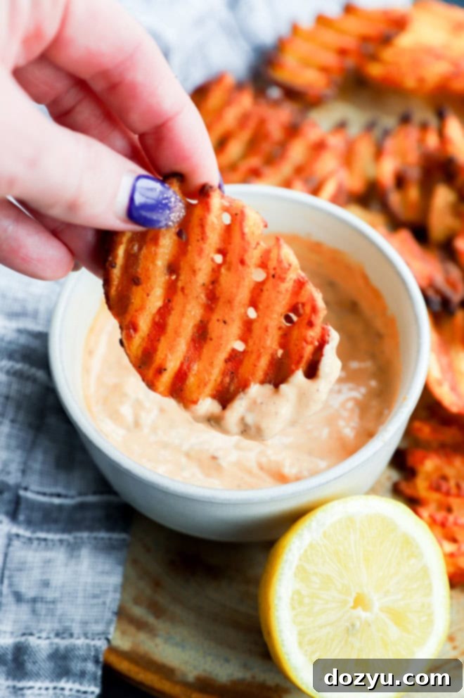 Bold Chipotle Aioli 9 hand holding fry dipping into the chipotle aioli in a bowl
