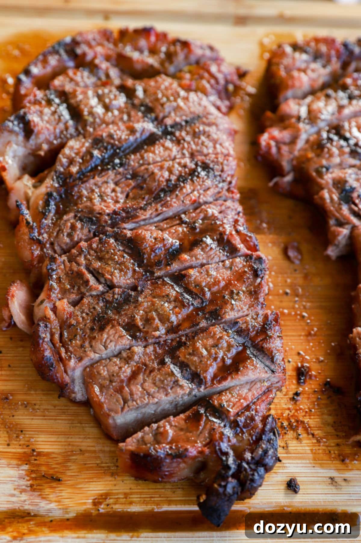 Grilled New York Strip Perfection 11 Juicy and tender sliced grilled New York strip steak on a platter