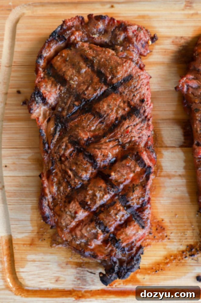 Grilled New York Strip Perfection 8 Close-up of a grilled cut of beef on a cutting board, showing perfect doneness and juicy texture