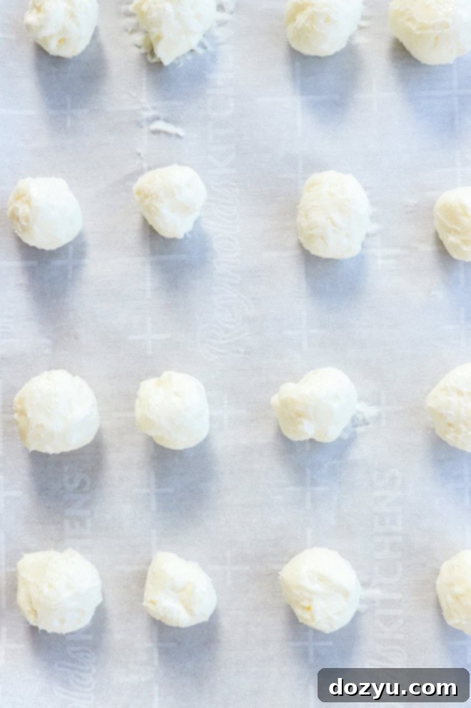 Raspberry Cheesecake Cookie Fusion 5 cream cheese filling balls on a baking sheet lined with parchment paper